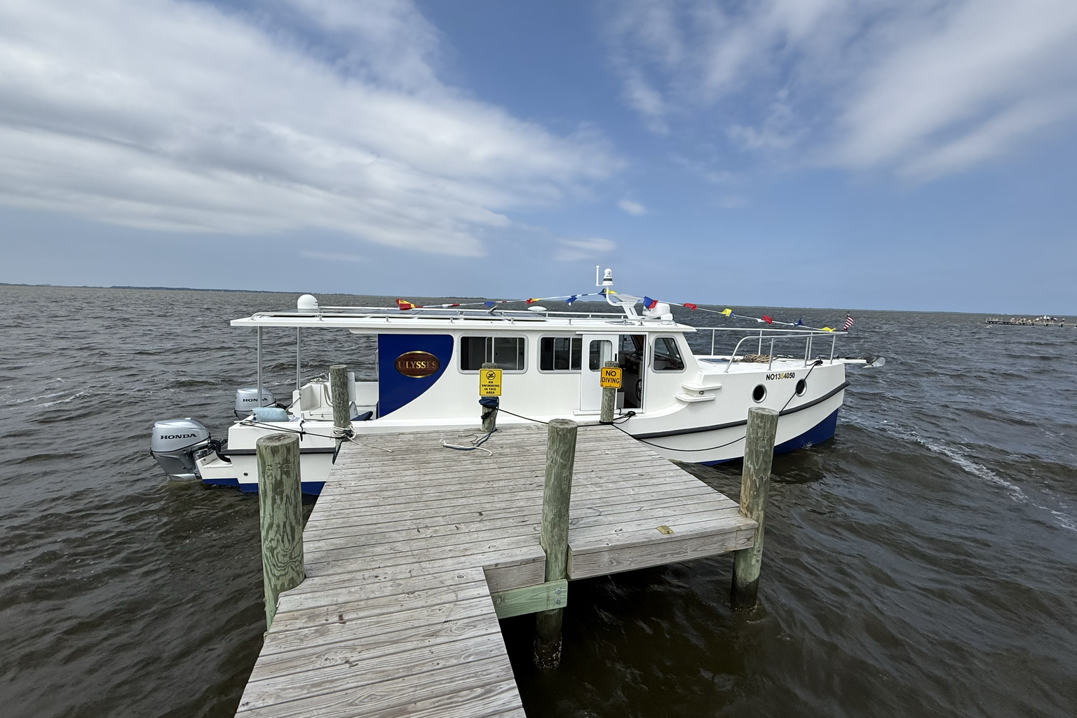 Ulysses tied at a quiet Currituck Sound dock near Waterlily on a clear morning.